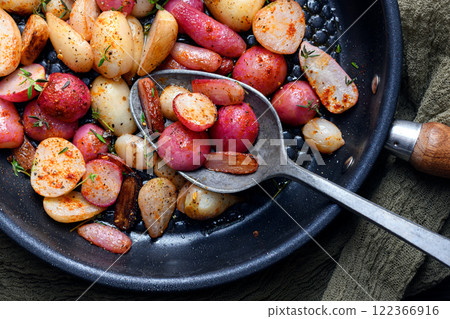 Fried radishes with herbs and spices on an iron frying pan Fried radishes with herbs and spices on an iron frying pan 122366916