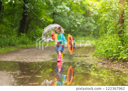 Kids playing in the rain with umbrella 122367962