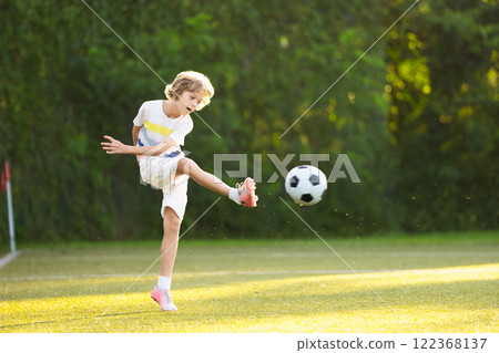 Child playing football. Kids play soccer. Child playing football. Kids play soccer. 122368137