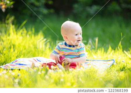 Baby boy with apple on family garden picnic 122368199