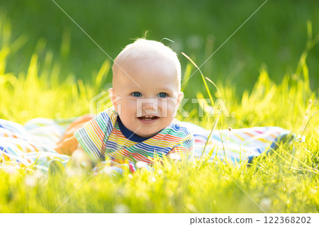 Baby boy with apple on family garden picnic 122368202