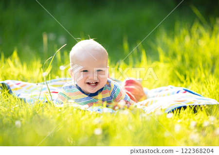 Baby boy with apple on family garden picnic Baby boy with apple on family garden picnic 122368204