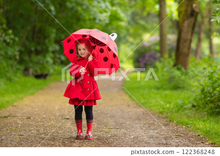 Little girl walking in the rain 122368248