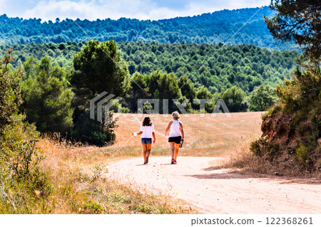 Mother with her daughter walking through nature along a forest path in Anoia, Barcelona Mother with her daughter walking through nature along a forest path in Anoia, Barcelona 122368261