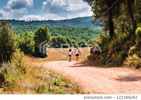 Mother with her daughter walking through nature along a forest path in Anoia, Barcelona Mother with her daughter walking through nature along a forest path in Anoia, Barcelona 122368262