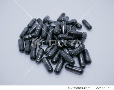 Activated Carbon Capsules pile on a white background. Digestion, detox medical concept Activated Carbon Capsules pile on a white background. Digestion, detox medical concept 122368268