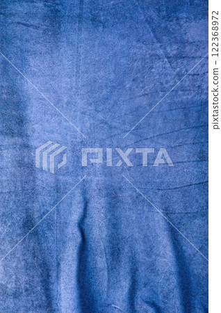 Vertical background of blue suede with scuffs and creases. 122368972