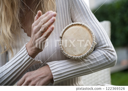 Female hand drumming in motion 122369326