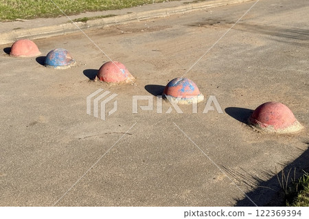 Red and blue restrictive hemispheres on the asphalt road in the parking area of the car and the pedestrian area of walking people at the street. Area for foot people Red and blue restrictive hemispheres on the asphalt road in the parking area of the car and the pedestrian area of walking people at the street. Area for foot people 122369394