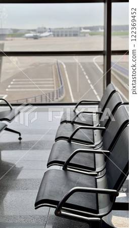 A row of stainless steel chairs in the station waiting area, each one filled with leatherette for sitting. The handrails are made of metal and steel, adding engineering touch to rectangular design A row of stainless steel chairs in the station waiting area, each one filled with leatherette for sitting. The handrails are made of metal and steel, adding engineering touch to rectangular design 122369452