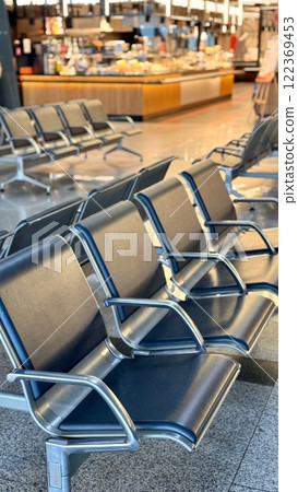 A row of stainless steel chairs in the station waiting area, each one filled with leatherette for sitting. The handrails are made of metal and steel, adding engineering touch to rectangular design A row of stainless steel chairs in the station waiting area, each one filled with leatherette for sitting. The handrails are made of metal and steel, adding engineering touch to rectangular design 122369453