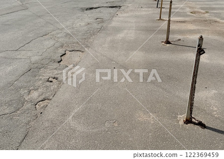 Metal restraints with an iron chain with a key for parking a car between poles outdoors in a special area on a summer day Metal restraints with an iron chain with a key for parking a car between poles outdoors in a special area on a summer day 122369459