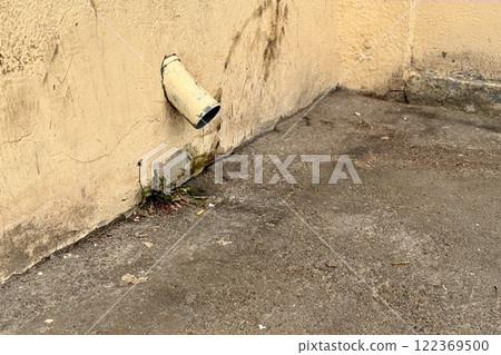 Yellow stainless steel drain pipe for drain pipe with water drainage from roof the house to the ground. It attaches to a wall of residential building 122369500