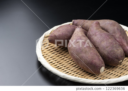 Sweet potatoes served on a bamboo sieve on a black background with copy space Sweet potatoes served on a bamboo sieve on a black background with copy space 122369636