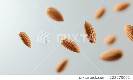 Many almonds are levitating on a light grey background, creating an interesting visual effect that emphasizes their natural texture and color, suggesting a healthy and nutritious snack 122370001