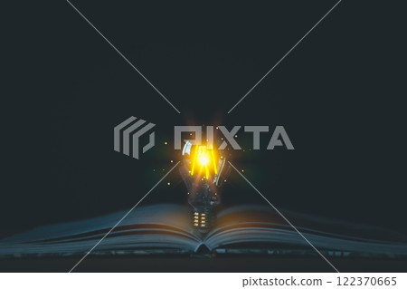 A glowing light bulb emerges from an open book, symbolizing knowledge, and new ideas. Concepts of innovation, education, and intellectual discovery, with a focus on enlightenment and inspiration. A glowing light bulb emerges from an open book, symbolizing knowledge, and new ideas. Concepts of innovation, education, and intellectual discovery, with a focus on enlightenment and inspiration. 122370665