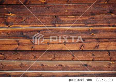 Weathered wooden planks revealing rich wood grain, natural texture highlighting rustic surfaces with organic knots and earthy character 122370825