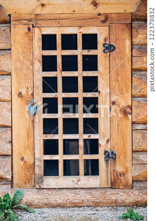 Locked wooden door with a barred window, attached to a traditional russian log cabin, representing security and rural life 122370832
