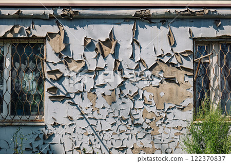 Weathered russian wall revealing crumbling paint, rusted metal grates, exposing architectural deterioration and urban neglect through textural details 122370837