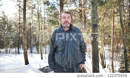 Homeless male experiencing alcoholism, sheltering within improvised winter woodland encampment Homeless male experiencing alcoholism, sheltering within improvised winter woodland encampment 122370959