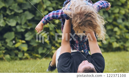 Father and daughter enjoying a playful moment in the garden, strengthening their bond through laughter and shared joy Father and daughter enjoying a playful moment in the garden, strengthening their bond through laughter and shared joy 122371108