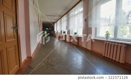 Walking down an old school corridor on the last day before summer break, sunlight streams through windows, casting light and shadows on a nostalgic scene Walking down an old school corridor on the last day before summer break, sunlight streams through windows, casting light and shadows on a nostalgic scene 122371126
