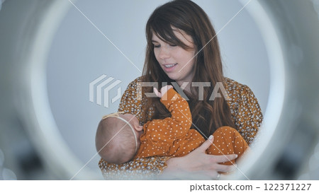 Mom cradling her infant daughter, enjoying a tender moment of bonding and love in soft, warm lighting Mom cradling her infant daughter, enjoying a tender moment of bonding and love in soft, warm lighting 122371227