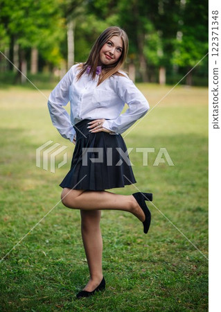 Cheerful young student smiling in a park, savoring her return to school after the summer break Cheerful young student smiling in a park, savoring her return to school after the summer break 122371348