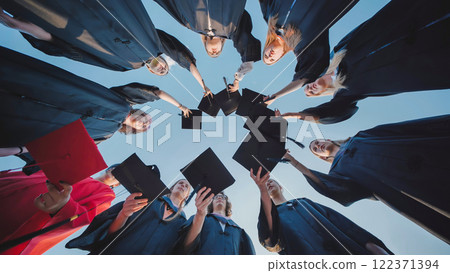 Students in a circle raising their graduation caps in celebration of their academic success Students in a circle raising their graduation caps in celebration of their academic success 122371394
