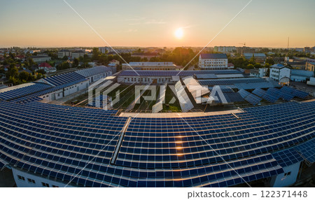 Aerial view of blue photovoltaic solar panels mounted on industrial building roof for producing green ecological electricity. Production of sustainable energy concept 122371448