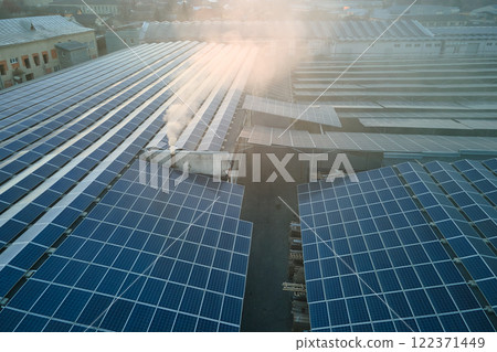 Aerial view of blue photovoltaic solar panels mounted on industrial building roof for producing green ecological electricity. Production of sustainable energy concept 122371449