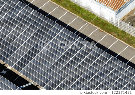 Aerial view of blue photovoltaic solar panels mounted on industrial building roof for producing green ecological electricity. Production of sustainable energy concept Aerial view of blue photovoltaic solar panels mounted on industrial building roof for producing green ecological electricity. Production of sustainable energy concept 122371451