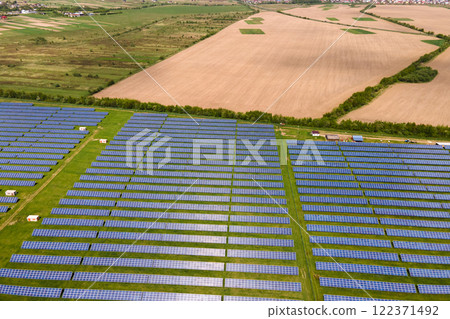 Aerial view of big sustainable electric power plant with many rows of solar photovoltaic panels for producing clean ecological electrical energy. Renewable electricity with zero emission concept. Aerial view of big sustainable electric power plant with many rows of solar photovoltaic panels for producing clean ecological electrical energy. Renewable electricity with zero emission concept. 122371492