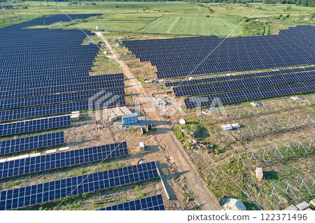 Aerial view of big electric power plant under construction with many rows of solar panels on metal frame for producing clean electrical energy. Development of renewable electricity sources 122371496