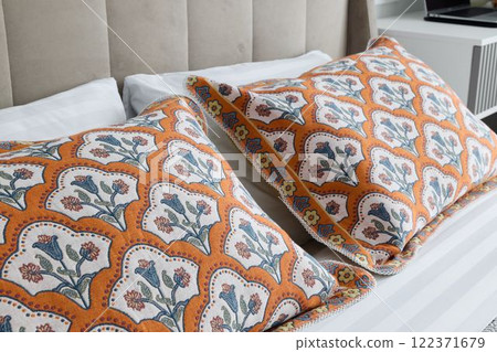 Stylish and Decorative Pillows Featuring a Beautiful Floral Pattern Placed on the Bed 122371679