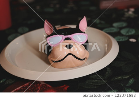 Adorable and Cute Dog Figurine Wearing Sunglasses Displayed on a Decorative Plate Adorable and Cute Dog Figurine Wearing Sunglasses Displayed on a Decorative Plate 122371688