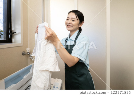A woman smiling while holding a washed T-shirt A woman smiling while holding a washed T-shirt 122371855
