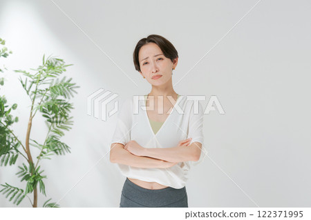 一名 30 多歲的女性,穿著瑜伽服,交叉雙臂 一名 30 多歲的女性,穿著瑜伽服,交叉雙臂 122371995