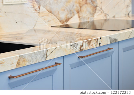 An Elegant Modern Kitchen featuring a stunning Marble Countertop and stylish Blue Cabinets 122372233