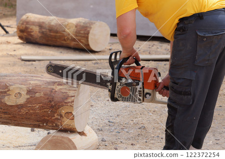 Chainsaw in Action Masterfully Cutting Logs with Precision and Exceptional Skill Chainsaw in Action Masterfully Cutting Logs with Precision and Exceptional Skill 122372254
