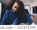 Smiling black girl looking down while playing in room 122372595