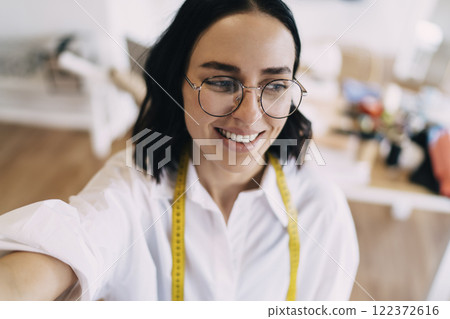 Happy woman in eyeglasses with tape measure Happy woman in eyeglasses with tape measure 122372616
