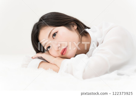 Beauty image: A young woman lying down in a white shirt, ennui Beauty image: A young woman lying down in a white shirt, ennui 122373925