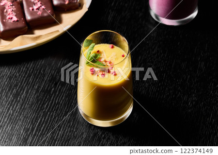 Enjoy a Refreshing and Delicious Mango Smoothie Served in an Elegant Glass along with Dessert Enjoy a Refreshing and Delicious Mango Smoothie Served in an Elegant Glass along with Dessert 122374149
