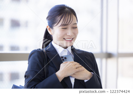 Job hunting: A woman happy while looking at her smartphone 122374424