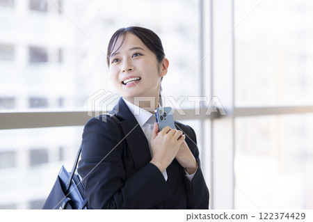 Job hunting: A woman happy while looking at her smartphone 122374429