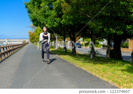 A cool woman walking along the riverside walkway Diet Walking Exercise A cool woman walking along the riverside walkway Diet Walking Exercise 122374607