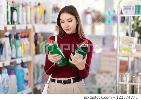 Brunette chooses dishwashing detergent Brunette chooses dishwashing detergent 122374773