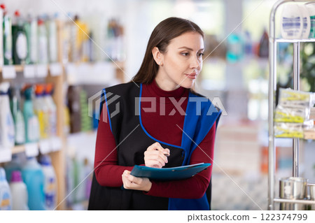 supermarket employee conducts an inventory supermarket employee conducts an inventory 122374799