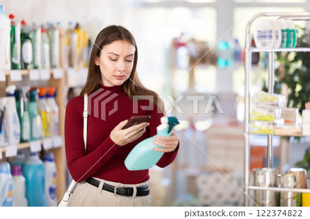 Woman scans barcode on spray package on phone 122374822